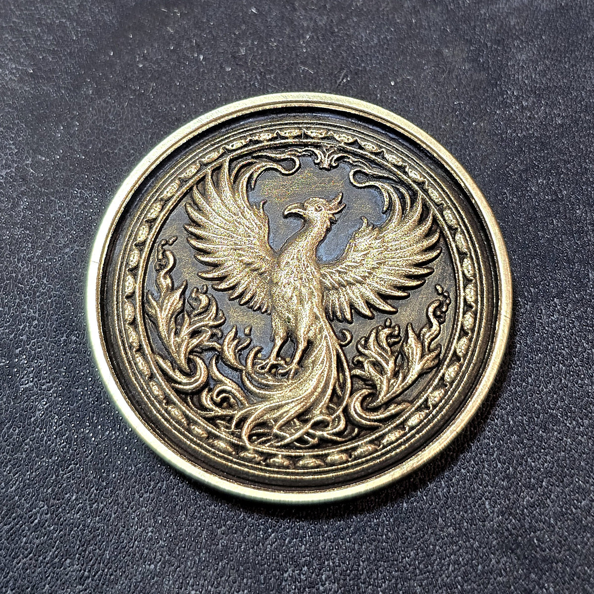 Phoenix brass coin with dark antiqued background