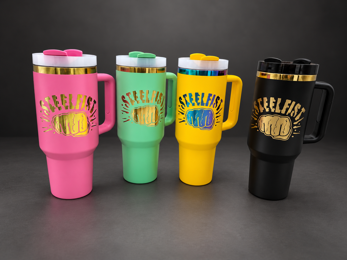 Pink, mint green, yellow and black Steelfist tumblers on a charcoal studio background